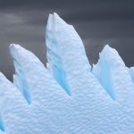Illustrative photograph: Sharp iceberg formations rise against dark, overcast skies, highlighting winter's harsh beauty.